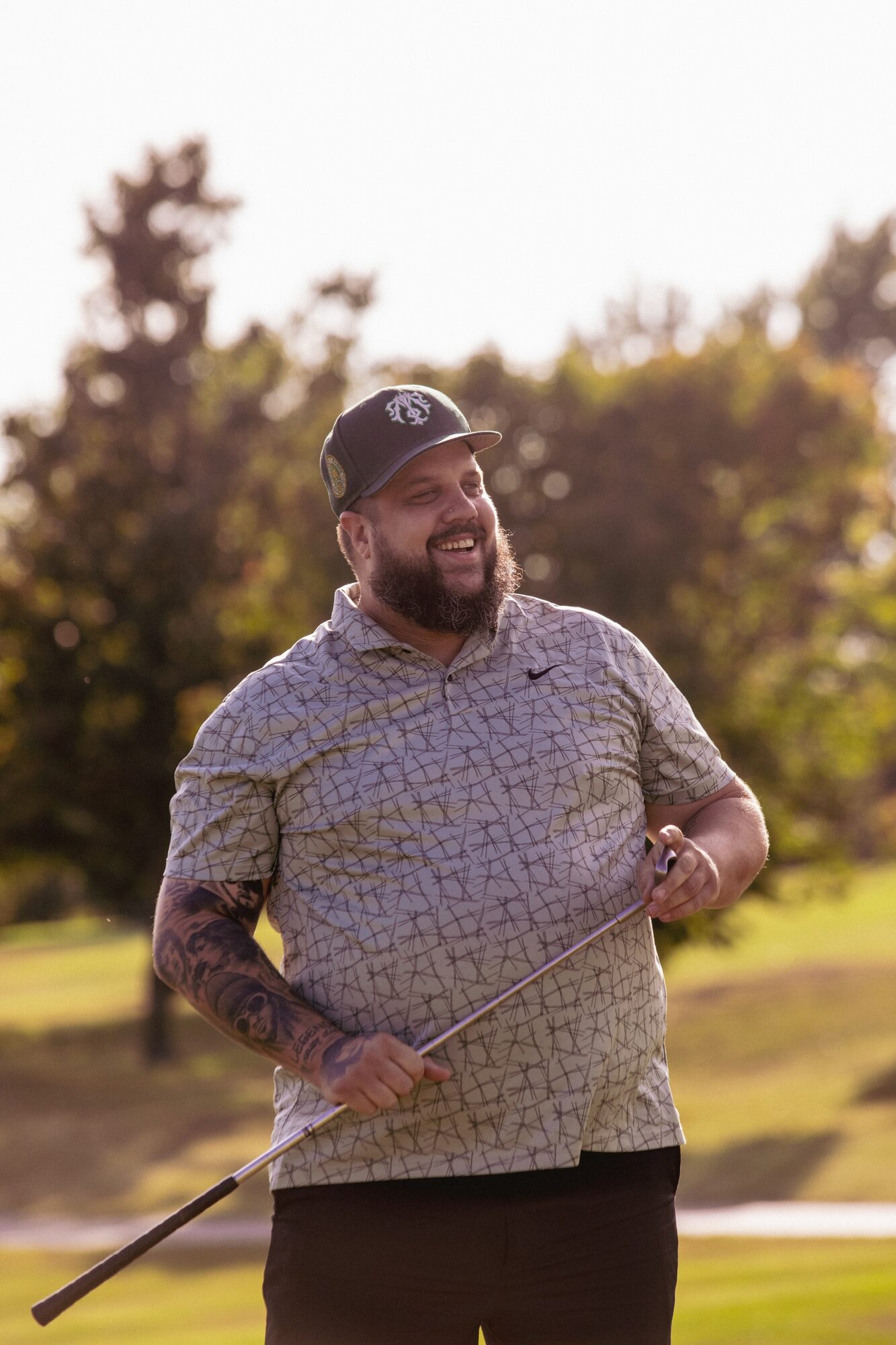League member laughing on the course at golden hour