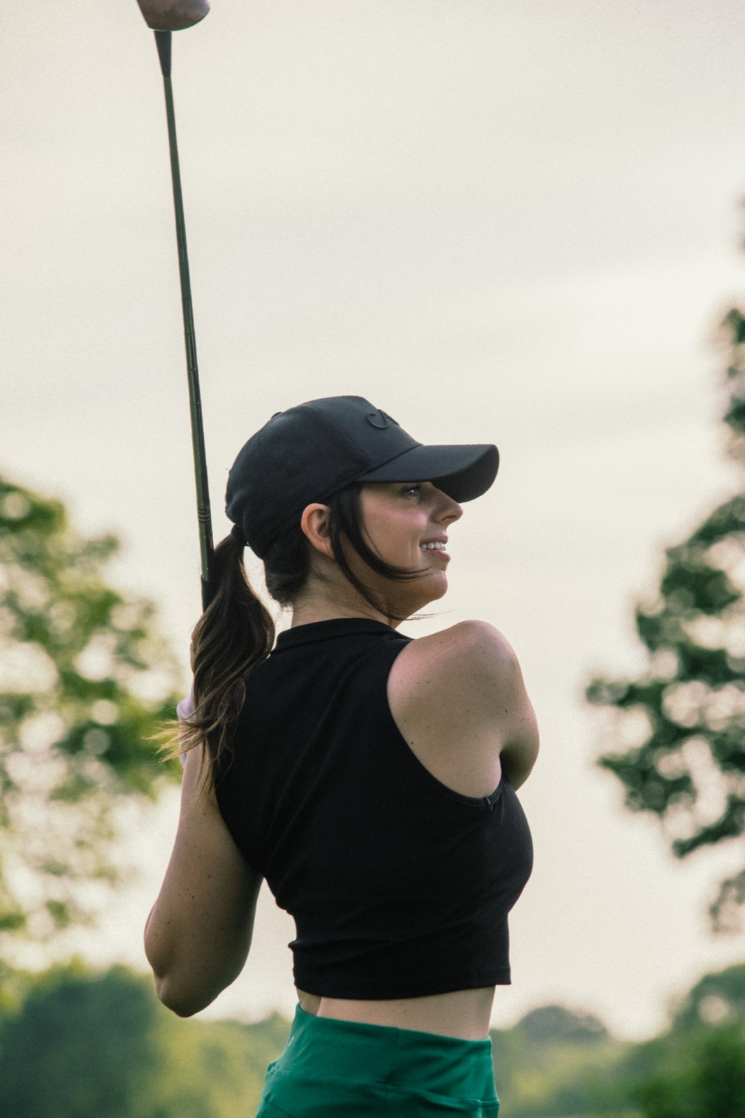 Player in a black top and cap looking up the fairway