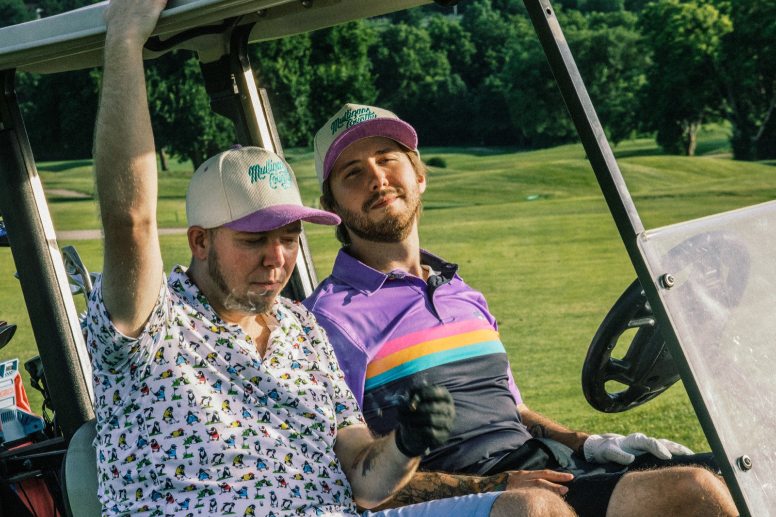 Two league members riding a cart at dusk