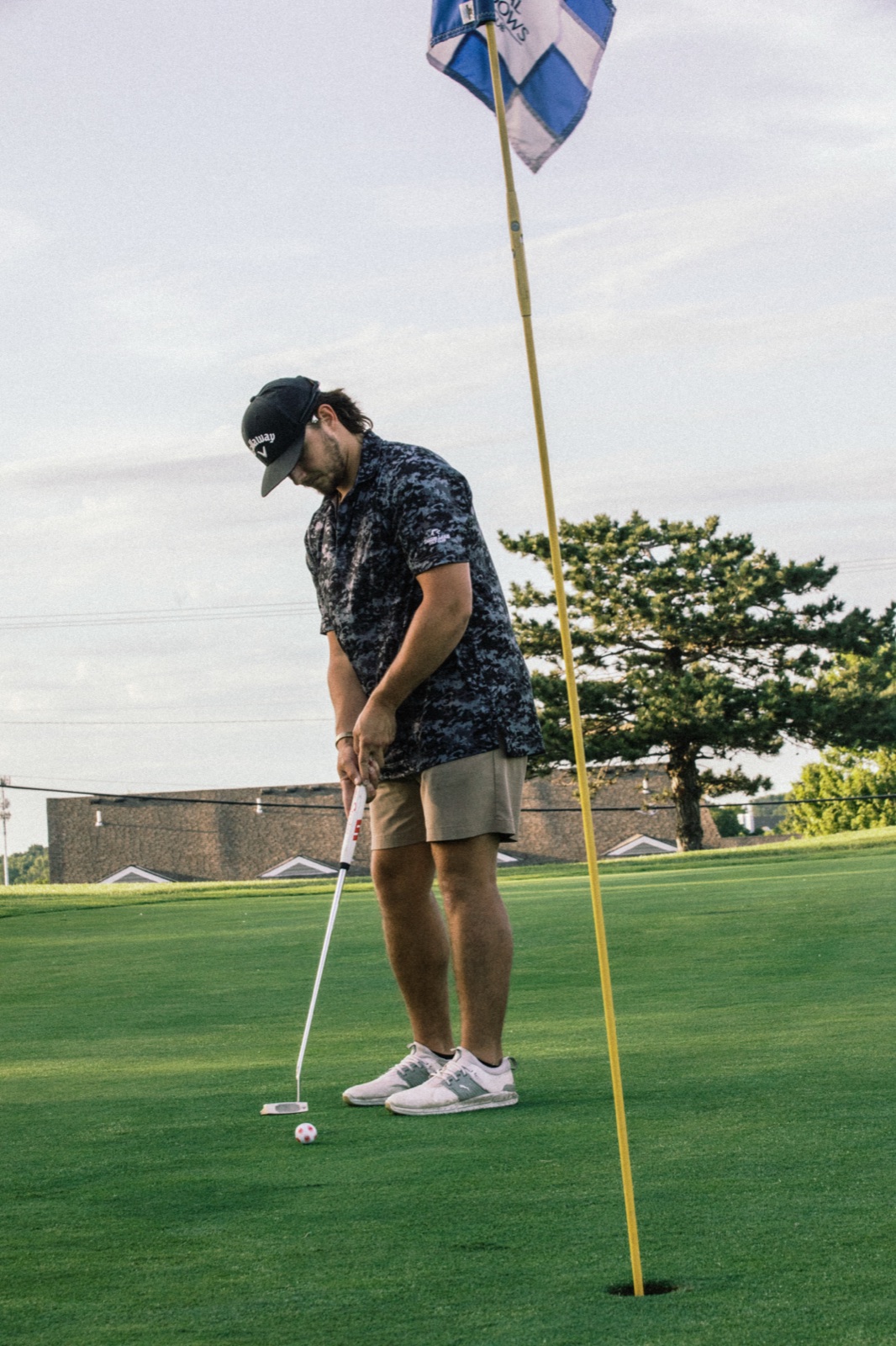 Player lining up a putt at the flag in the evening light