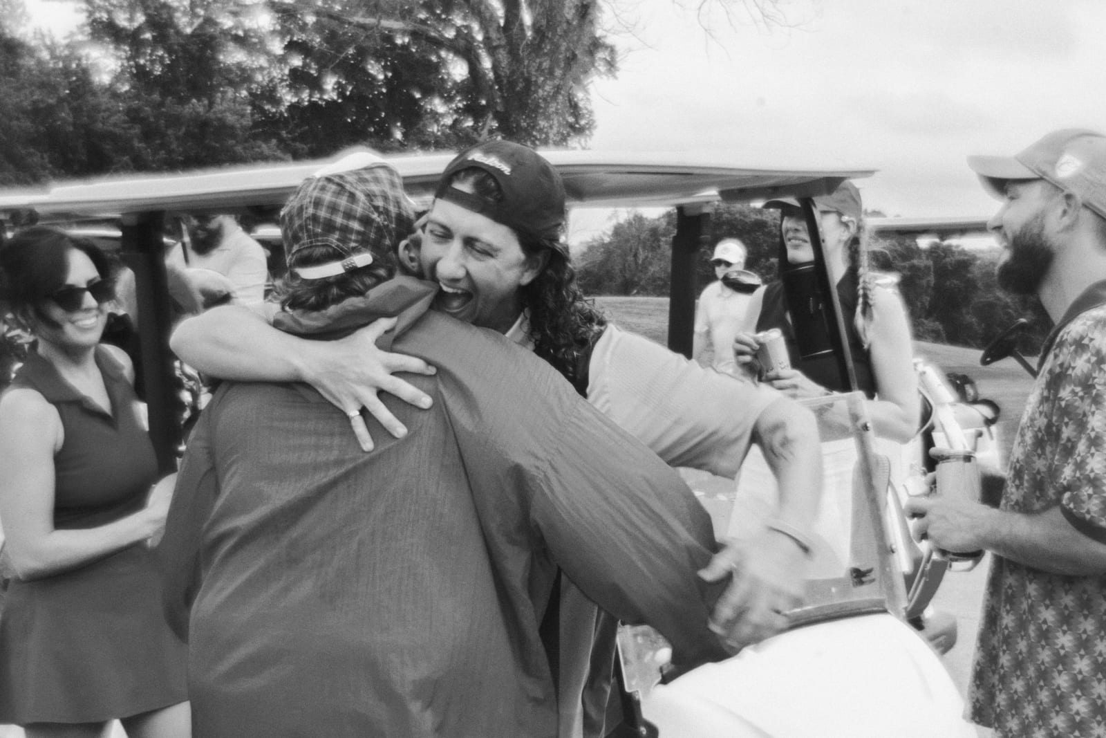 Two league members hugging by the carts after the round
