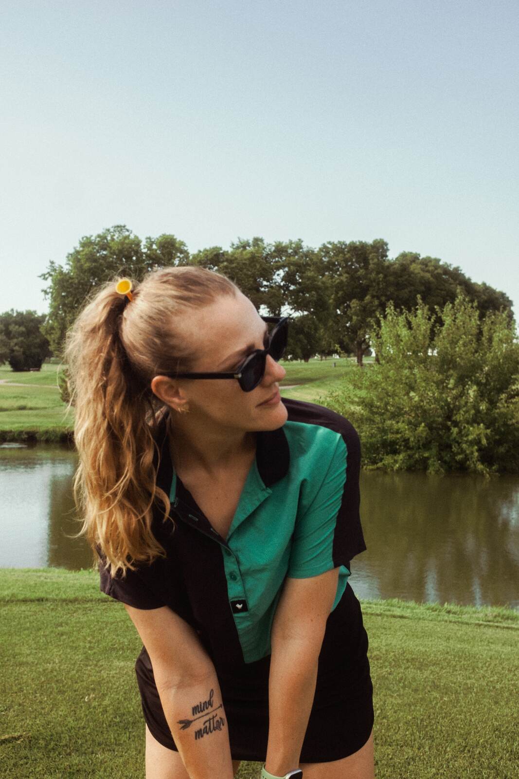 League member in a teal and black polo laughing by the pond